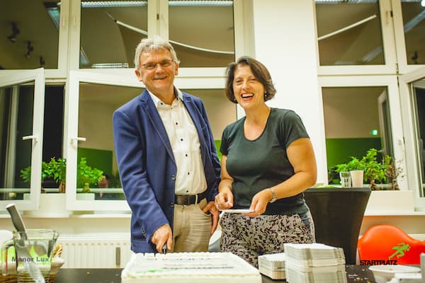 Dr. Lorenz Gräf und Martha Giannakoudi von schneiden die Geburtstagstorte